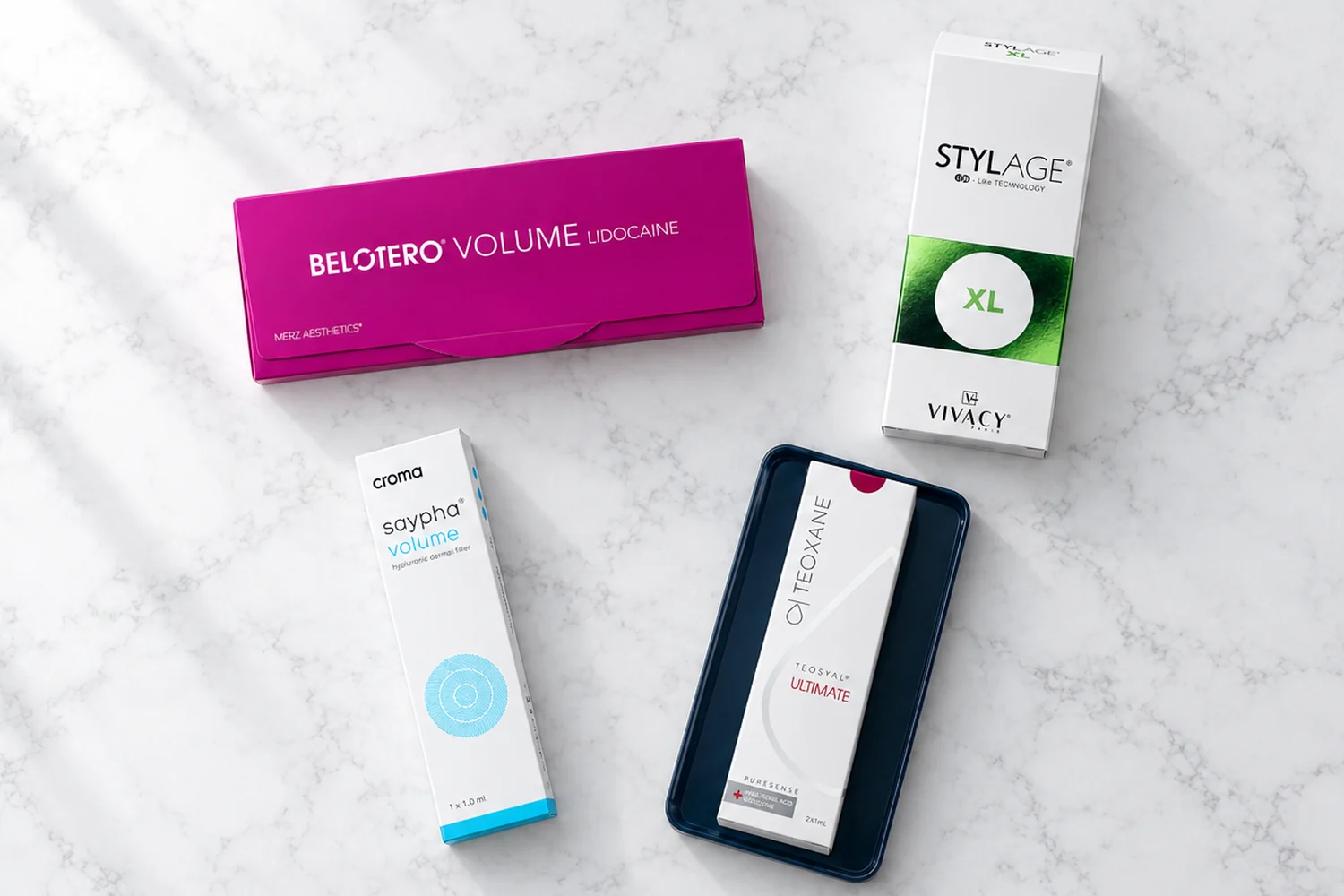 Belotero Volume, Stylage XL, Saypha Volume and Teosyal Ultimate dermal fillers on white marble